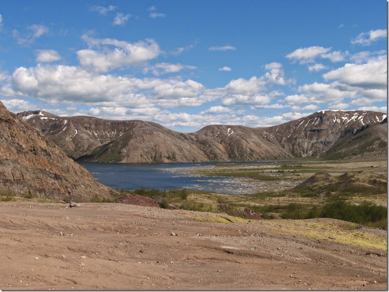 High hills with a lake. The surrounding land is barren after a volcanic eruption