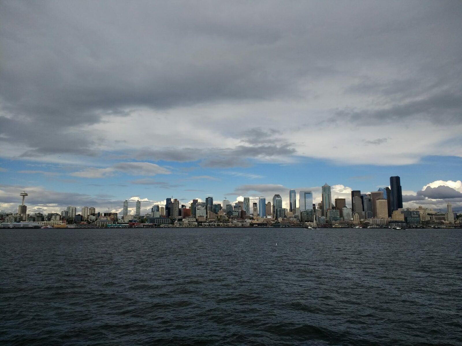 water and a city skyline against a cloudy sky