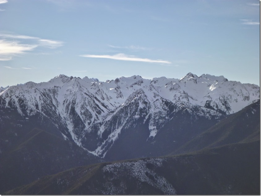 Snow capped mountains seen across a valley on an Olympic National Park itinerary