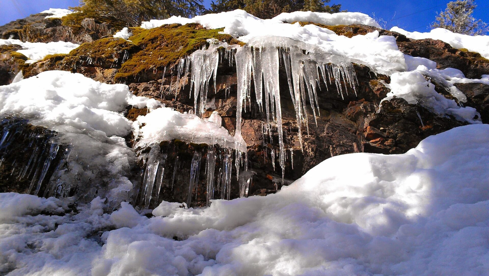 Big icicles hang from snowy rocks