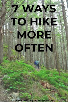 Two people walking on a trail through a green forest. They are looking up at the tall trees. Text reads: 7 ways to hike more often