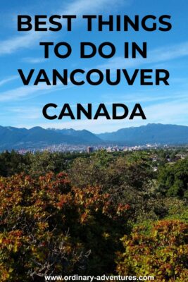 Trees in the foreground and city buildings in the background with forested hills and mountains in the distance. Text reads Best things to do in Vancouver Canada