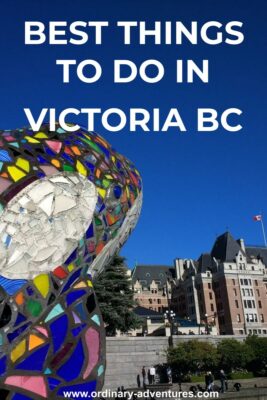 Walking around the inner harbor is one of the best things to do in Victoria! Here a colorful orca sculpture is in the foreground and a large stone hotel in the background. It's a blue sky day. Text reads best things to do in Victoria BC