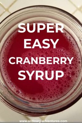 Bright red liquid in a clear glass jar. Text reads: Super easy cranberry syrup