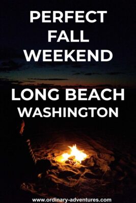 A beach fire after sunset. A person is sitting next to the fire and barely visible. A bit of sunset color remains in the sky. Text reads: Perfect fall weekend Long Beach Washington