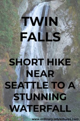 A wide and high waterfall cascades over a vertical rock face. There are trees and green shrubs around it. Text reads: Twin Falls. Short hike near seattle to a stunning waterfall