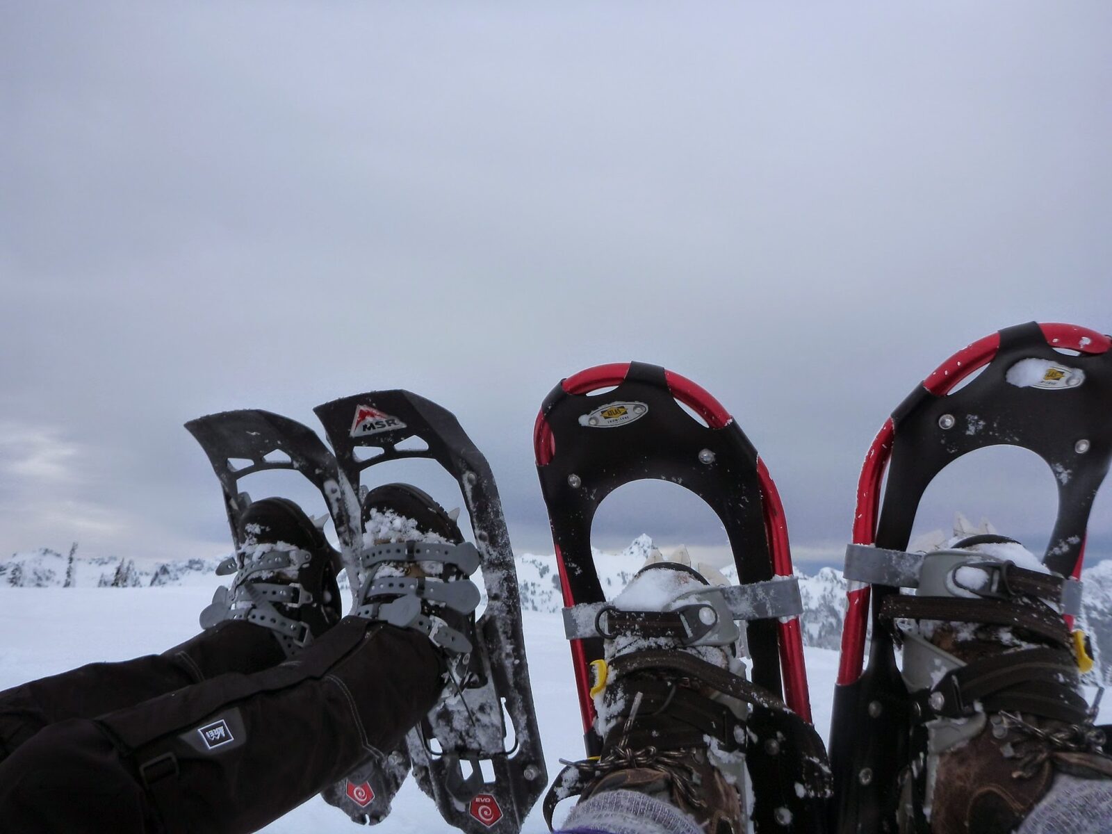 Two sets of feet in snowshoes. 