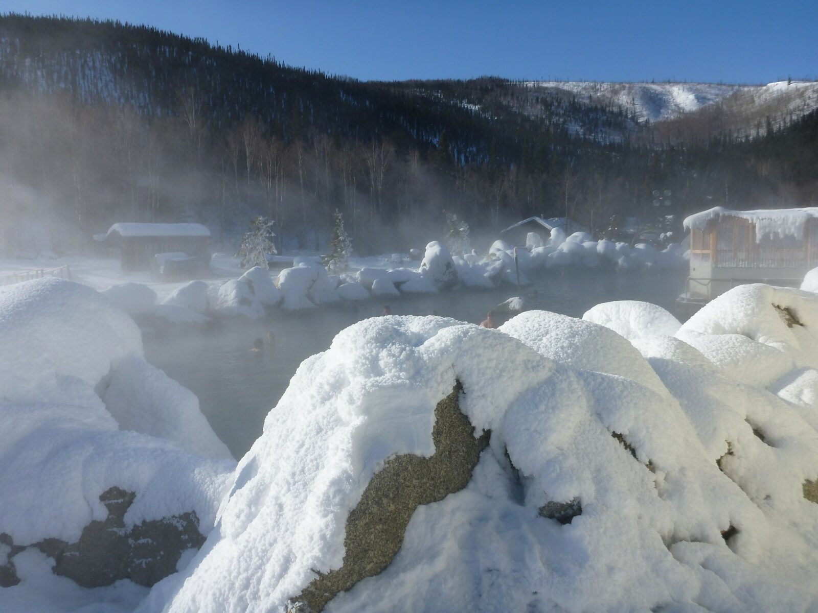 wintry hot springs surrounded by icy and snowy rocks at Chena Hot springs