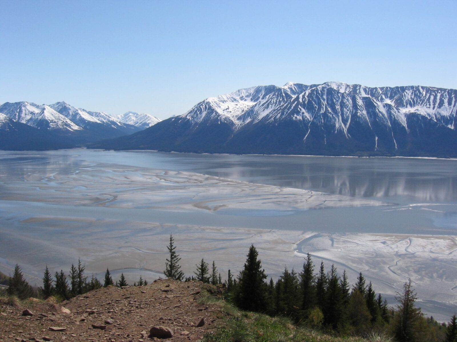 Hiking is one of the best things to do in Anchorage and the Bird Ridge Trail is a tough but spectacular view hike with this view of tideflats, water and across the water mountains with some snow on top