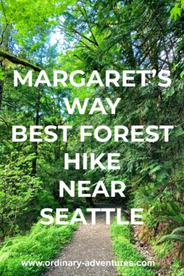 A dirt trail goes through a forest with many shades of green in the trees and undergrowth. Text reads: Margaret's Way, best forest hike near seattle