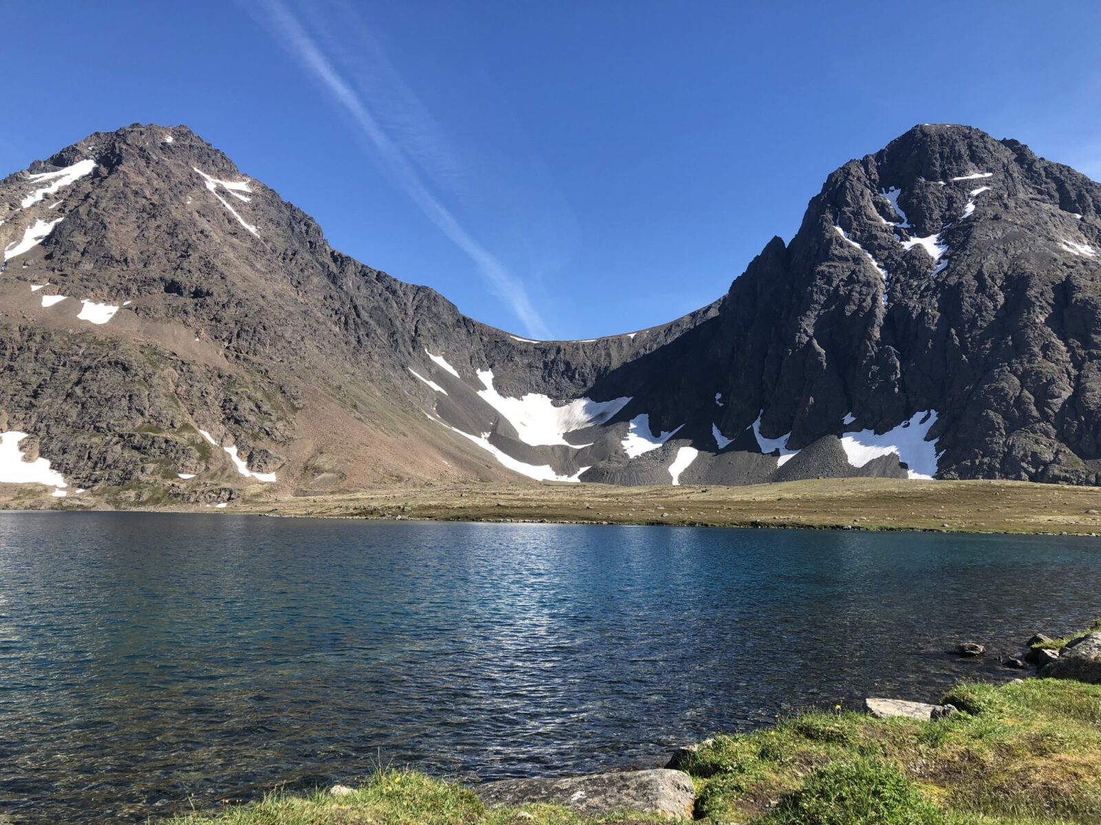 Rabbit Lake near Anchorage is an alpine lake surrounded by rocky mountains with bits of snow clinging all summer