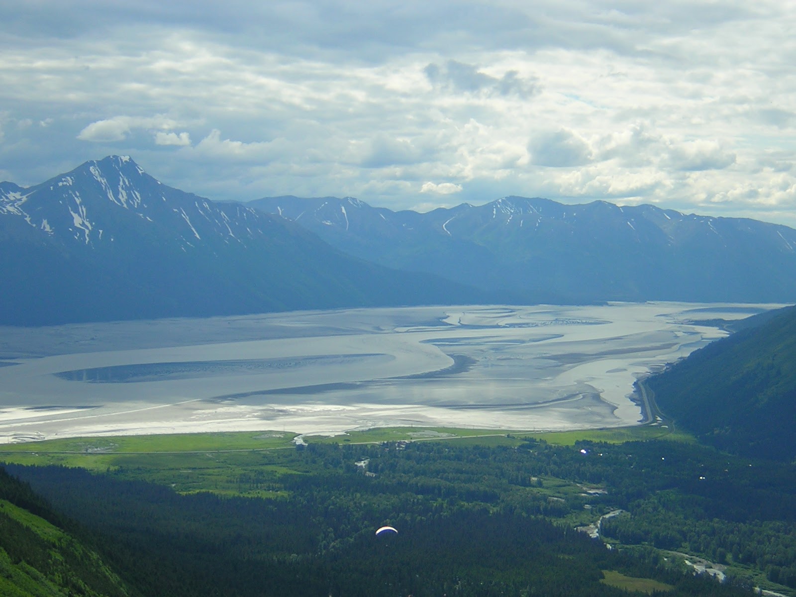 Water at low tide stretches beyond the small town of Girdwood with high mountains behind. The view is from the Alyeska Gondola, one of the best things to do in Anchorage