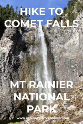 A waterfall comes down a cliff face with evergreen trees at the top of the cliff on a sunny day. Text reads: Hike to Comet Falls Mt Rainier National Park