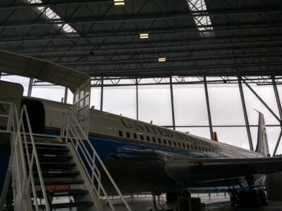 An old Air Force airplane in a hanger with stairs going up to the door